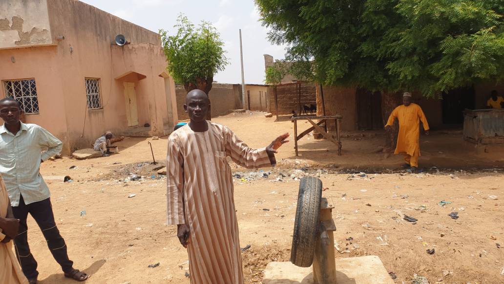 A resident standing beside a non functioning borehole