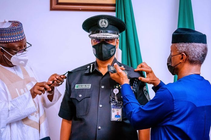 Vice President Yemi Osinbajo SAN decorates the new Acting Inspector General of The Nigeria Police Force Usman Alkali Baba at the State House, Abuja